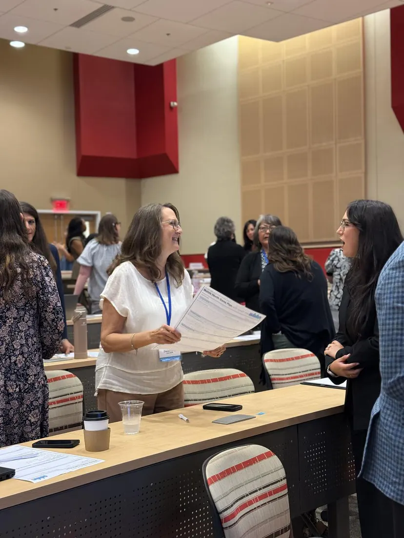 An attendee sharing handouts during a break