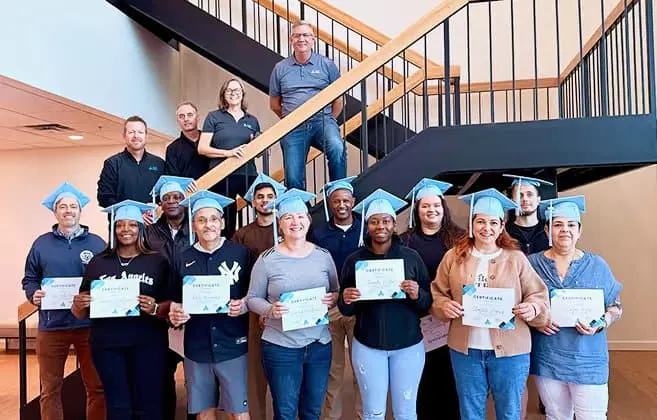 Course graduates holding their certificates