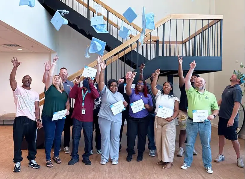 Operator training graduates celebrating with their certificates