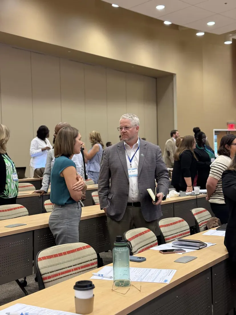 Two attendees in conversation across the session tables